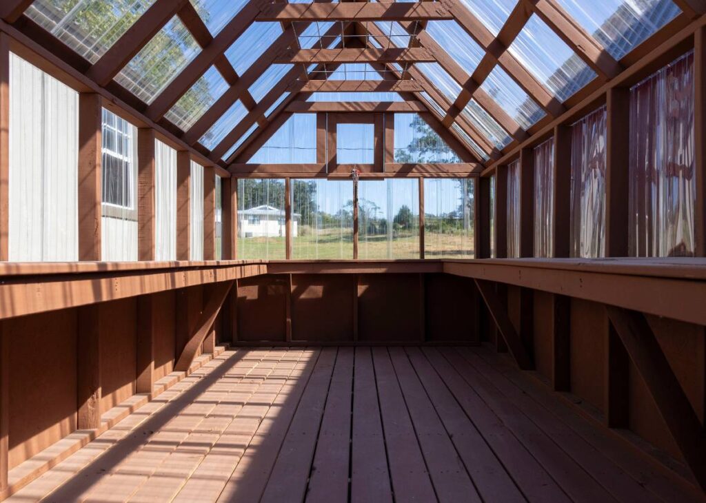 Interior of red backyard greenhouse at Tiny Hive in Giddings, TX