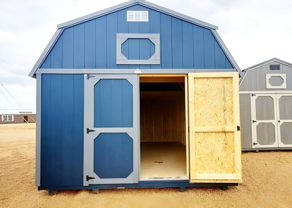Blue lofted barn storage shed with gray trim, double doors, and an open doorway showing the unfinished wood interior